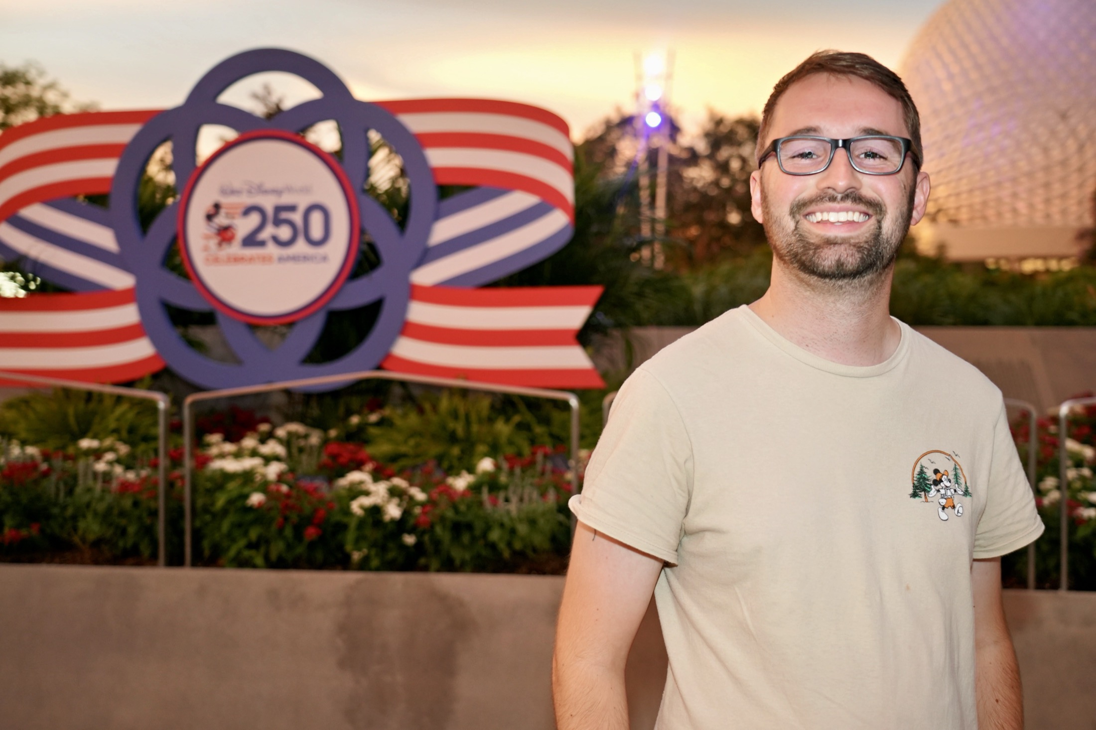 Cam smiling near an America 250 display at EPCOT