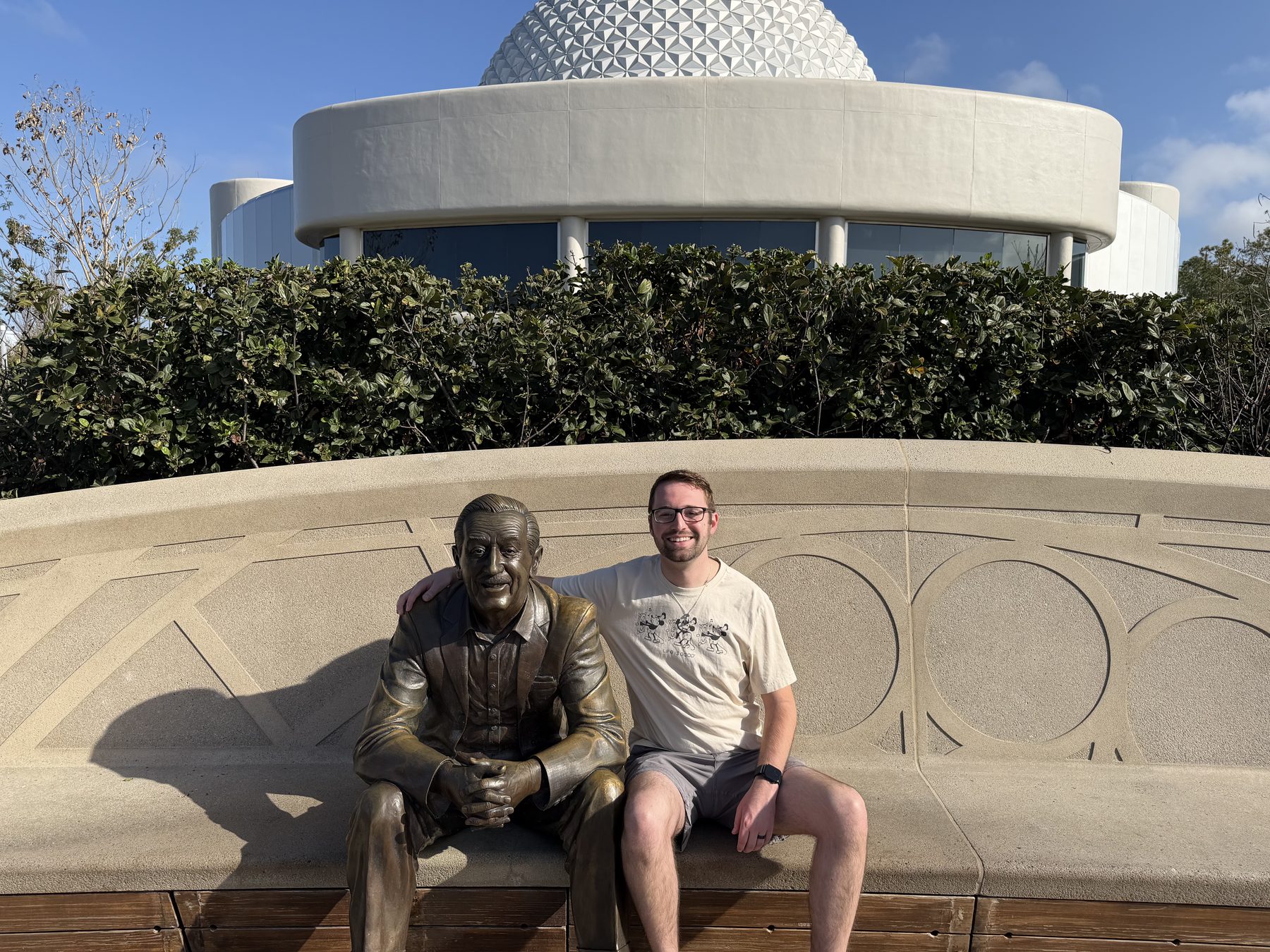 Cam sitting with the Walt Disney statue at EPCOT