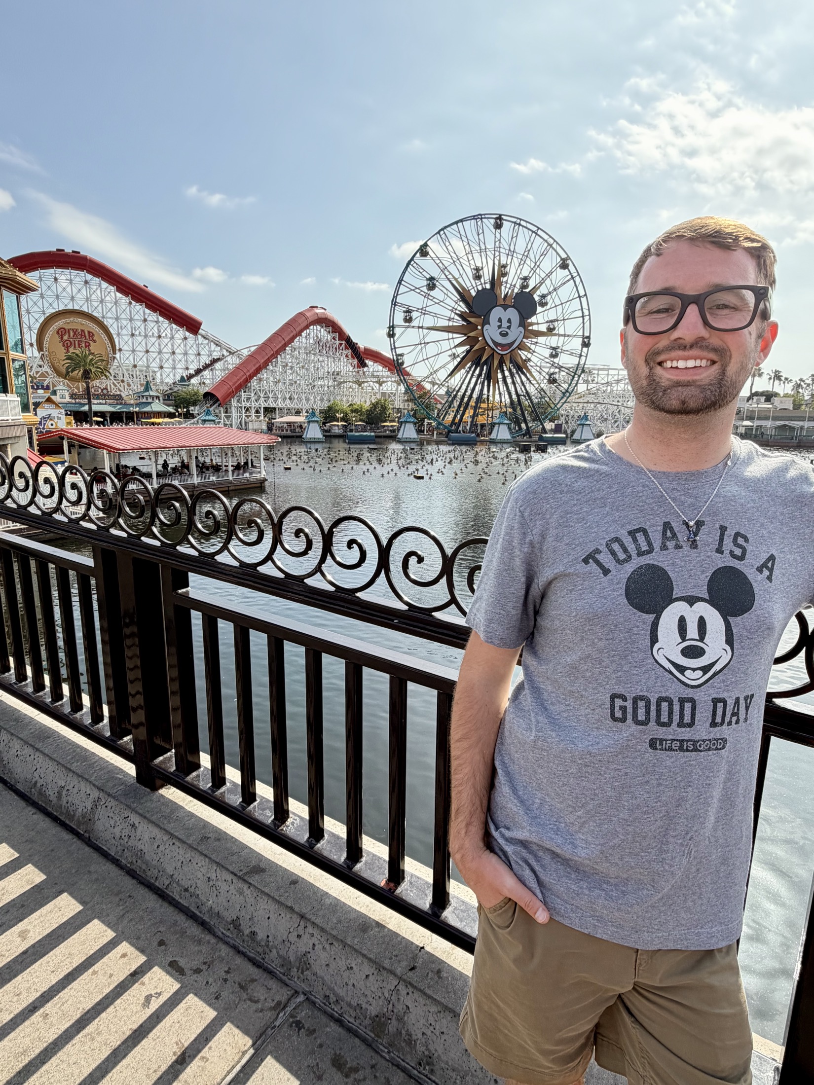 Cam smiling near Pixar Pier and the Mickey ferris wheel