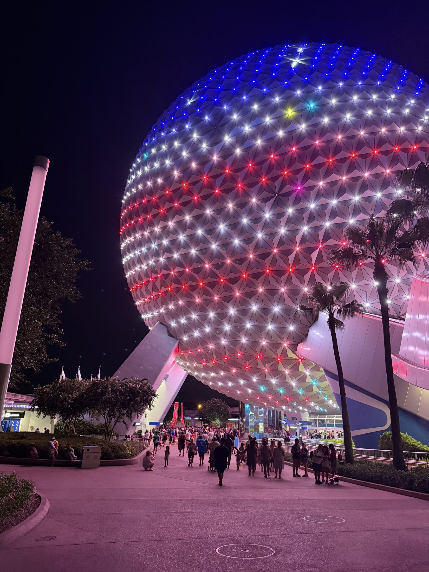 Spaceship Earth glowing with colorful lights at night